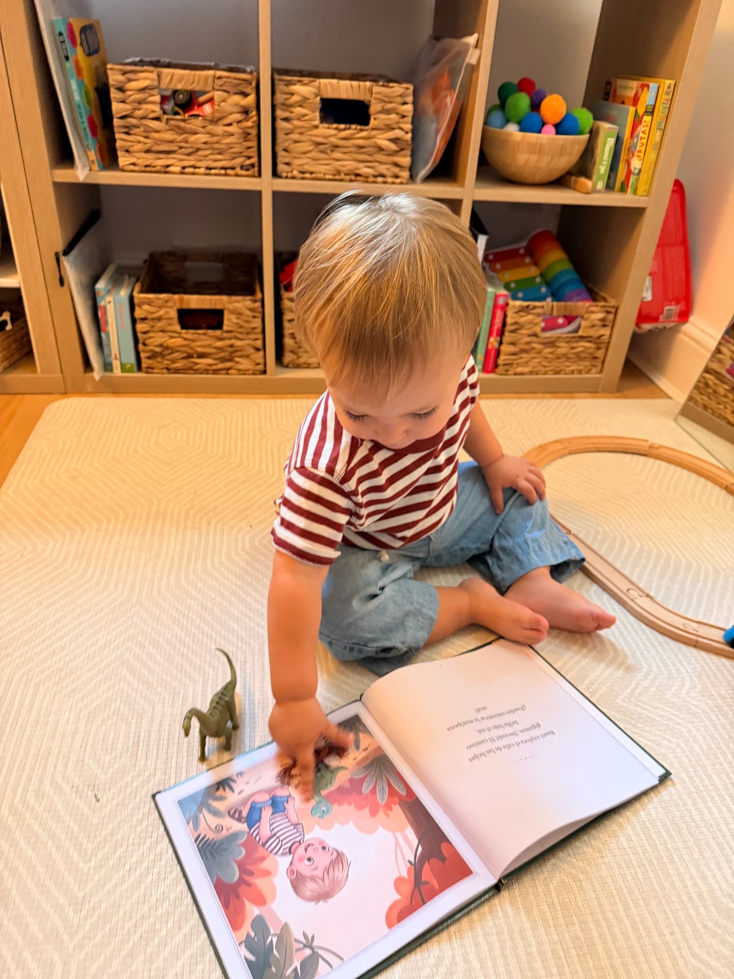 A small boy pointing at the illustrated version of himself in an open printed book